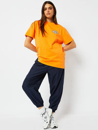 Money Can Buy Happiness Oversized T-Shirt in Orange Tops & T-Shirts Skinnydip London